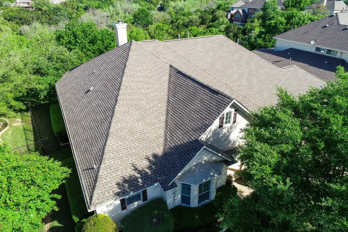 Recent Houston roofing project: finished shingle roof surrounded by trees