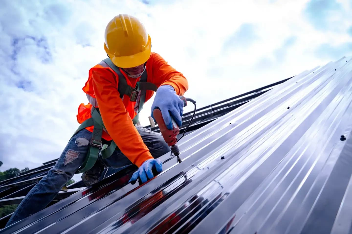 Roofer installing standing seam metal roofing